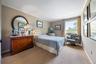 Bedroom with wallpapered walls, ornamental molding, and carpet floors