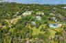 Aerial view of property's location featuring a large body of water and a heavily wooded area