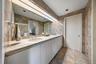 Full bath featuring double vanity and tile walls