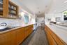 Kitchen with glass insert cabinets, brown cabinetry, granite tiled floors, tasteful backsplash, and recessed lighting