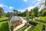 Swimming pool with a lawn, a patio, and view of scattered trees