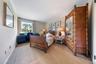 Carpeted bedroom with crown molding and wallpapered walls