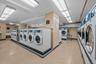 Shared laundry featuring tile walls, washing machine and dryer, and light flooring