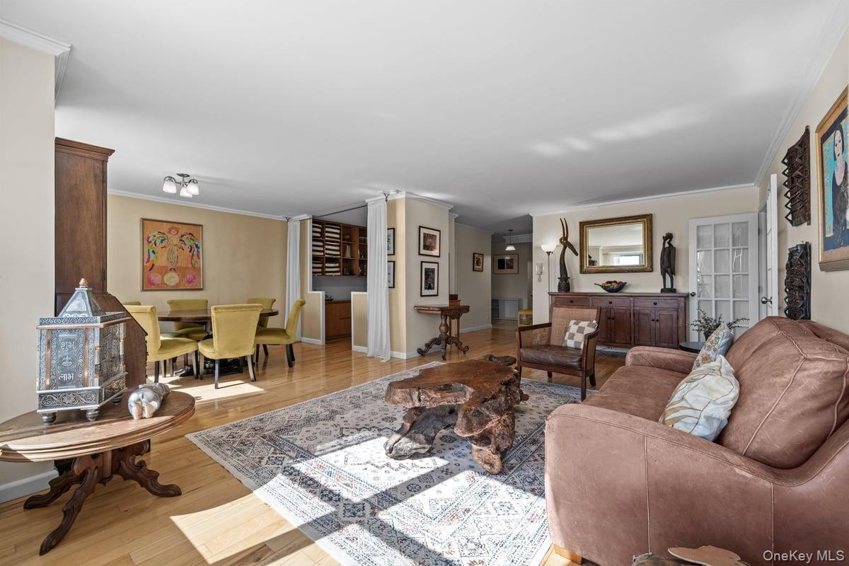 Living area with crown molding and light wood-style flooring