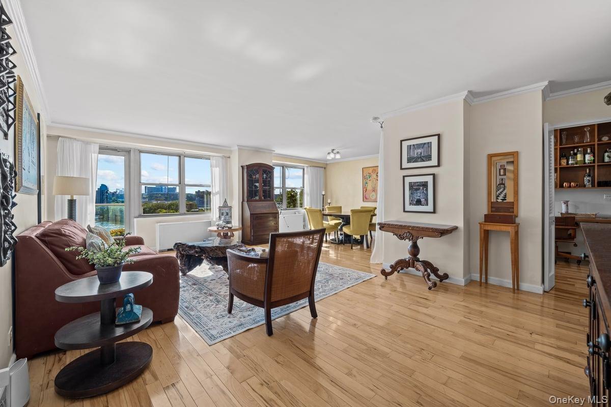 Living room with ornamental molding and light wood-style flooring
