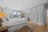 Bedroom with light wood-style flooring and ensuite bath