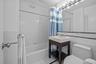Full bathroom with tile walls, shower / bathtub combination with curtain, and light tile patterned floors