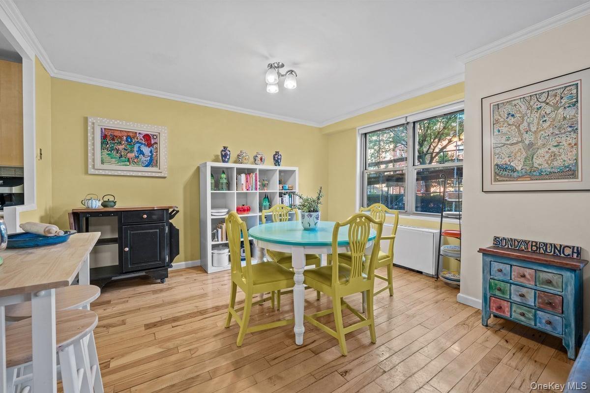 Dining area featuring ornamental molding and light wood-type flooring