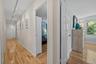 Hallway featuring light wood-style flooring and track lighting