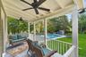 Deck with an outdoor living space, an outbuilding, view of wooded area, and a patio