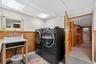 Washroom featuring wood walls, a wainscoted wall, and washer and clothes dryer