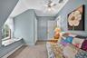 Bedroom #5 featuring a baseboard heating unit, light colored carpet, and crown molding