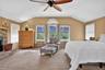Bedroom with carpet floors, multiple windows, lofted ceiling, a fireplace, and ceiling fan