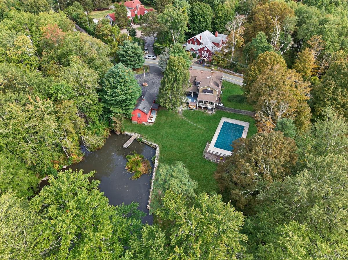 Aerial view of property's location with a pool area and beautiful private pond
