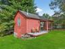Back of property featuring a chimney, a lawn, a wooden deck, and a shingled roof