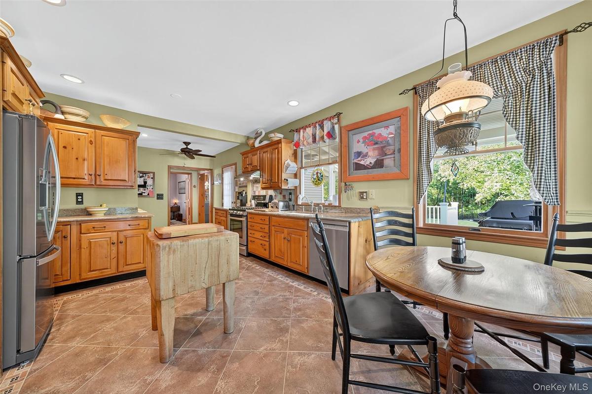 Kitchen featuring stainless steel appliances, hanging light fixtures, recessed lighting, a ceiling fan, and light tile patterned floors