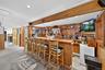 Indoor wet bar featuring wood walls, butcher block counters, recessed lighting, brown cabinetry, and open shelves
