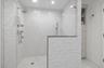 Bathroom with marble finish floor, a stall shower, and baseboards