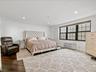 Bedroom with a wall mounted air conditioner, crown molding, baseboards, wood finished floors, and recessed lighting