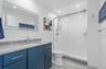 Bathroom with vanity, toilet, recessed lighting, and a shower stall