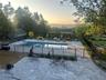 Pool at dusk featuring a patio and a community pool