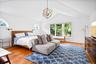 Primary bedroom with lofted ceiling, light wood finished floors, wooden ceiling, and a chandelier