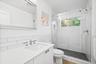 Full bath featuring vanity, a shower stall, and tile walls