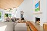 Living room with a lit fireplace, wood finished floors, wood ceiling, a skylight, and high vaulted ceiling