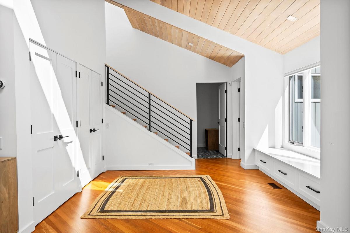 Entrance foyer featuring stairs, light wood-type flooring, and ceiling