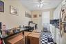 Kitchen with tile patterned floors, range with gas stovetop, freestanding refrigerator, a ceiling fan, and white cabinets