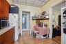 Kitchen featuring stainless steel microwave, freestanding refrigerator, a paneled ceiling, light wood-style floors, and tile countertops
