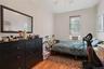 Bedroom with light wood-type flooring, a ceiling fan, and a decorative wall