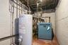 Utility room featuring water heater and a heating unit