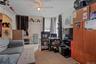 Carpeted living area featuring radiator heating unit and a ceiling fan