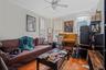 Living room featuring wood-type flooring, ceiling fan, and crown molding