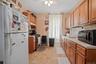 Kitchen featuring freestanding refrigerator, gas range, a ceiling fan, backsplash, and light countertops