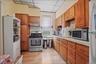 Kitchen featuring a paneled ceiling, appliances with stainless steel finishes, light countertops, backsplash, and light wood-style floors