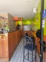 Bar featuring a wall unit AC, dark countertops, and wood finish floors