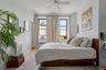 Bedroom featuring crown molding, light wood finished floors, ceiling fan, and radiator