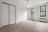Unfurnished bedroom with radiator heating unit, light wood-style flooring, and a closet