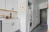 Washroom featuring stacked washing machine and dryer and dark tile patterned flooring