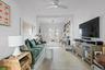 Living room featuring a desk, light wood finished floors, french doors, and a ceiling fan