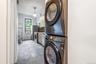 Laundry area featuring stacked washer / drying machine and light tile patterned floors