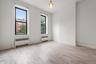 Empty room featuring light wood-style flooring, radiator heating unit, and crown molding