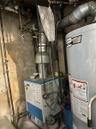 Utility room with gas water heater and a heating unit