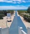Carpeted wall to lifeguarded ocean beach, umbrellas and chairs.