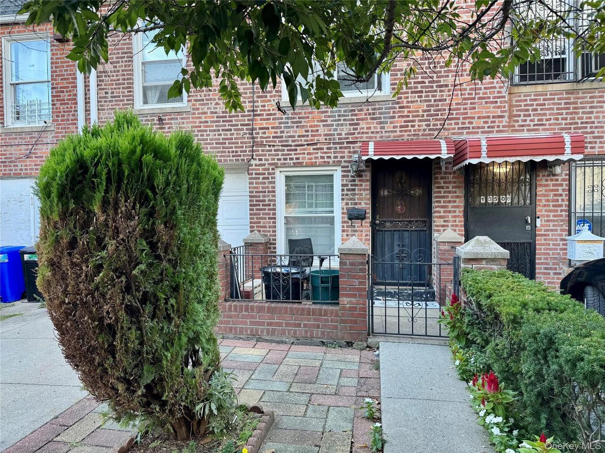 View of exterior entry featuring brick siding and a gate