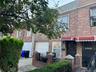 View of front of home featuring brick siding and roof with shingles