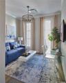 Living area featuring wood finished floors, crown molding, and a chandelier