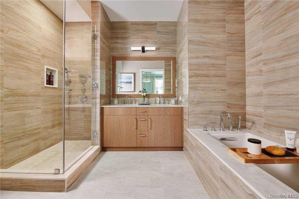 Bathroom featuring tile walls, a stall shower, vanity, a bath, and light tile patterned flooring